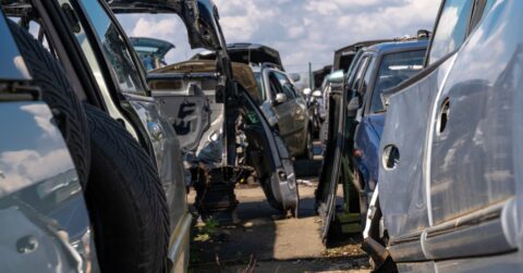 Random dismembered old car parts in a scrap yard.