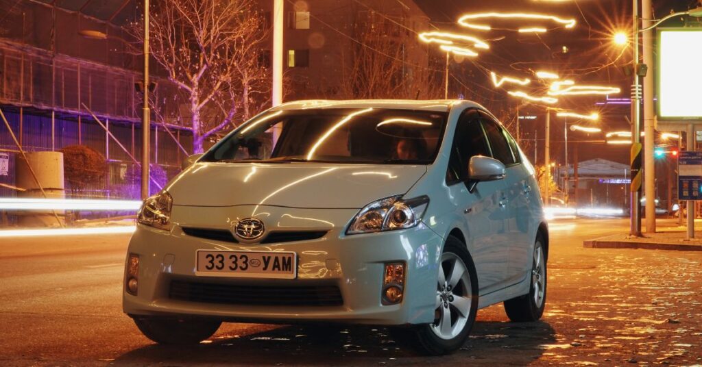 A sedan car parked on the road at night.